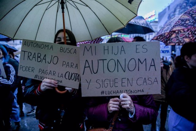 Archivo - Varias personas sostienen pancartas en una manifestación para reivindicar unas cuotas “justas” para trabajadores autónomos