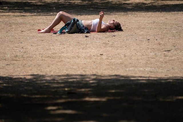 Una mujer tumbada en un parque de Londres durante la ola de calor de julio