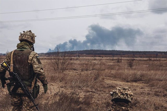 Archivo - Un soldado ucraniano observa desde la lejanía una columna de humo en la región de Irpín