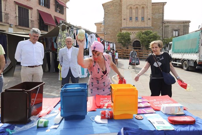 El gerente del Consorcio de Residuos, Fernando Mendoza, y el consejero de Cohesión Territorial, Bernardo Ciriza, observan la actuación teatralizada organizada en el mercadillo de Sesma para sensibilizar de forma sobre la prevención de residuos.