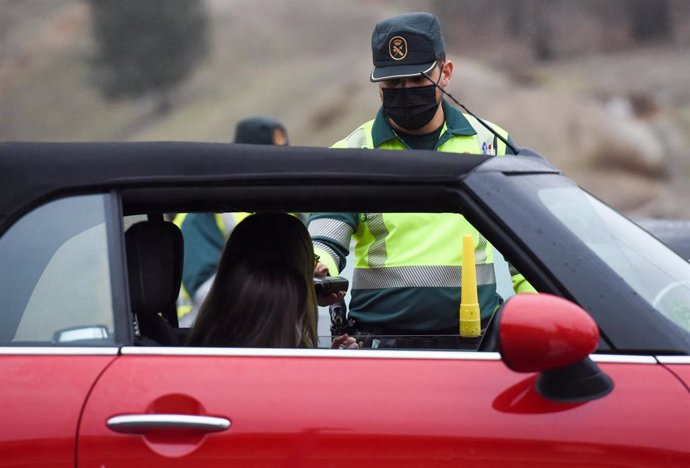 Archivo - Dos agentes de la Guardia Civil realizan un control de alcohol y drogas a una mujer en el kilómetro 13,600 de la carretera A-1, a 23 de diciembre de 2021, en Madrid (España). 