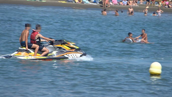 Pasajero en moto acuática sin chaleco salvavidas en una playa de Málaga