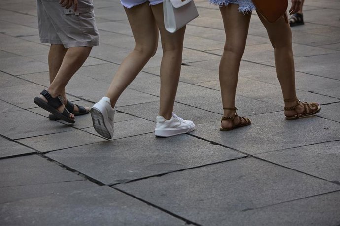 Varias personas pasean por la calle, durante una ola de calor 