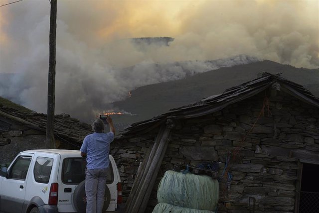Un hombre fotografía las llamas del incendio, a 10 de agosto de 2022, en Laza, Ourense, Galicia (España). Según la última actualización provisional de la Consellería de Medio Rural, en el municipio de Laza han ardido unas 740 hectáreas por un incendio que