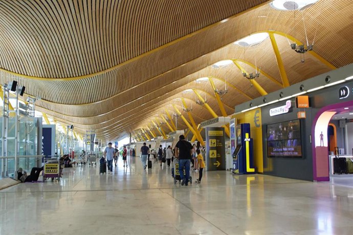 Archivo - Varias personas en la terminal T4 del aeropuerto Adolfo Suárez Madrid-Barajas, a 11 de julio de 2022, en Madrid (España). Durante estos días, muchos viajeros tienen que enfrentarse a largas esperas en las zonas de los controles, retrasos en lo