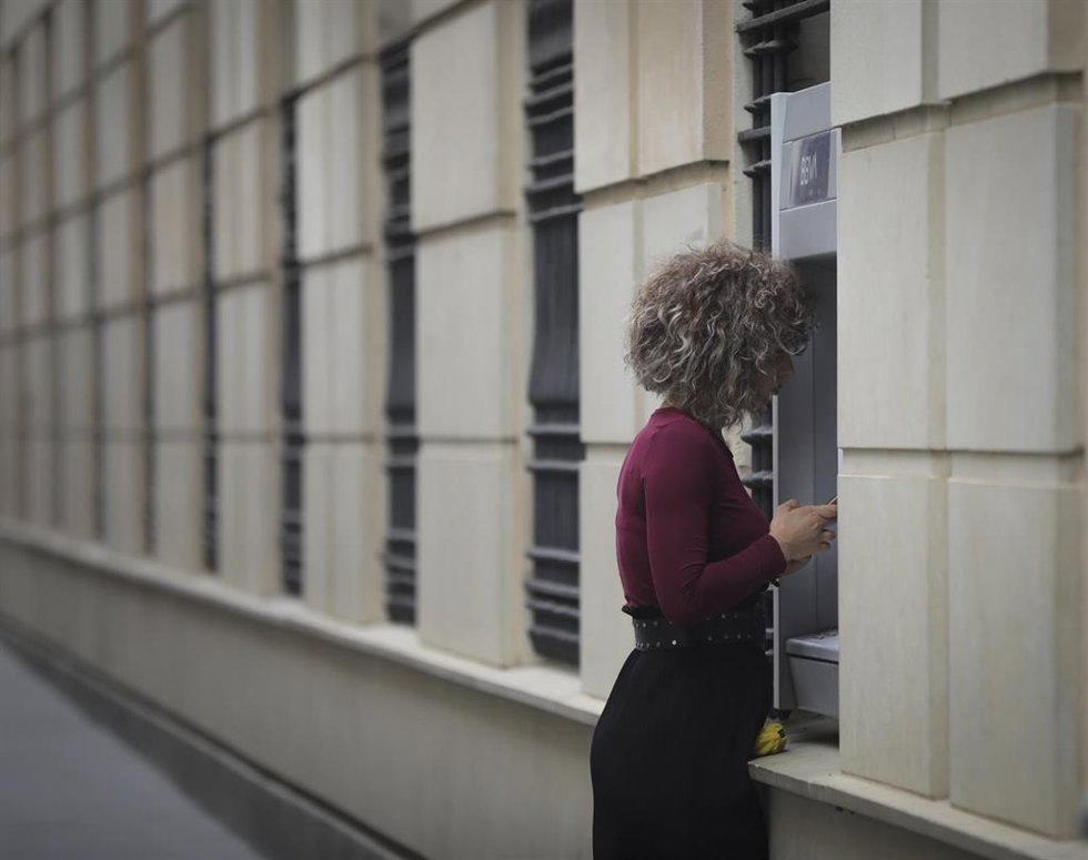Archivo - Una mujer en un cajero automático