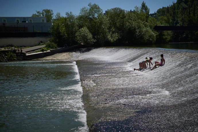 Archivo - Foto de archivo de varias personas dándose un baño en el río Arga.