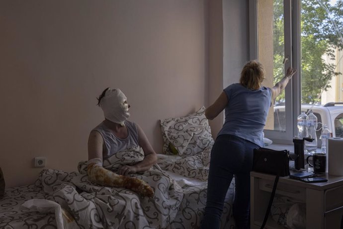 Jul 15, 2022 - Vinnytsia, Vinnytsia Oblast, Ukraine - RYNA VOLKOVA, 49, who was badly burned as a result of a missile strike, sits while her sister closes the window, after receiving treatment in a ward in the burns unit of a hospital in Vinnytsia. VOLK