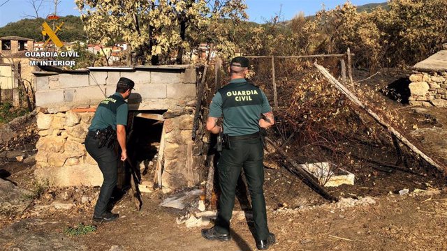 Dos agentes de la Guardia Civil en el incendio de una parcela en Cuacos de Yuste (Cáceres).