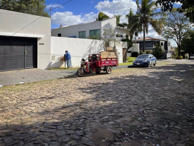 Archivo - Una mujer busca en la basura junto a un vehículo en una calle de Asunción, Paraguay