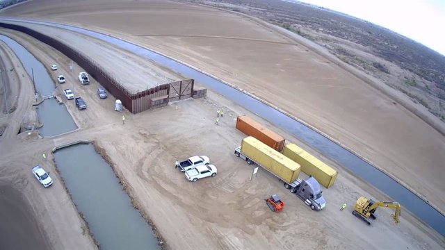 Camiones dejan contenedores para bloquear la frontera de Estados Unidos con México en Arizona