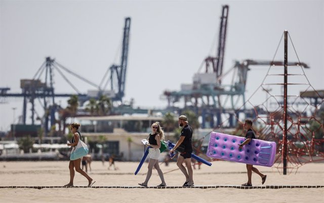 Bañistas se dirigen a la Playa de la Malvarrosa, a 12 de agosto de 2022, en Valencia, Comunidad Valenciana (España). 