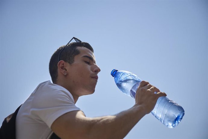 Archivo - Un joven bebe agua