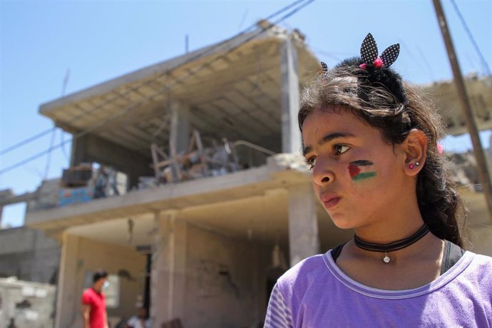 Una niña palestina junto a un edificio destruido en la Franja de Gaza