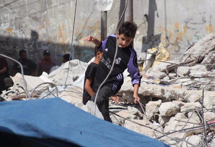 Niños palestinos jugando entre escombros en Rafá, en el sur de la Franja de Gaza
