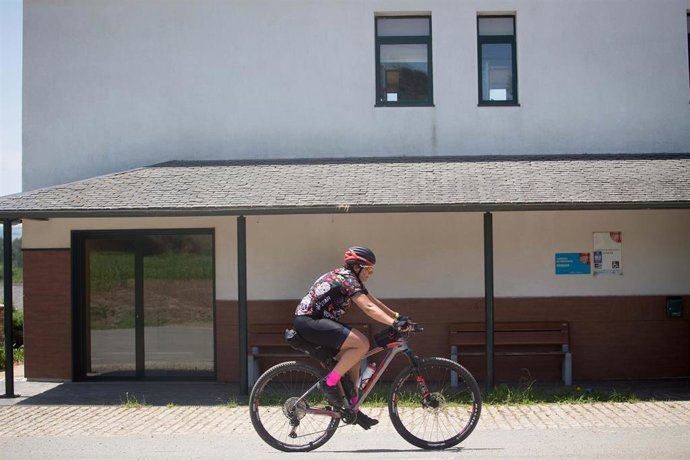 Archivo - Un ciclista pasa por delante de un albergue, en una foto de archivo.