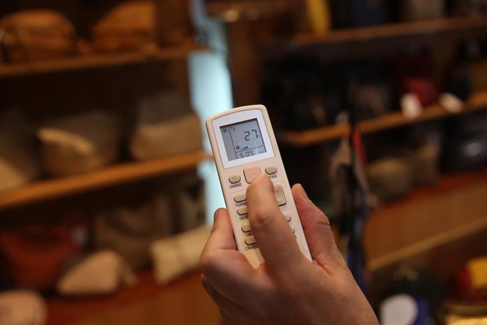 Un trabajador pone la temperatura de su establecimiento a 27 grados, a 10 de agosto de 2022, en Madrid (España). Hoy entran en vigor las primeras medidas del Plan de medidas de Ahorro y Eficiencia energética de la Administración General del Estado (AGE)