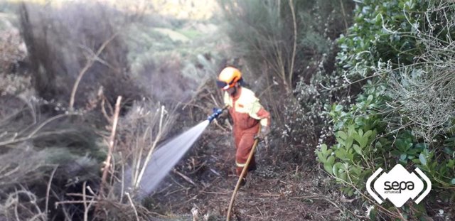 Bombero trabajando en labores de extinción de un incendio forestal en Ibias