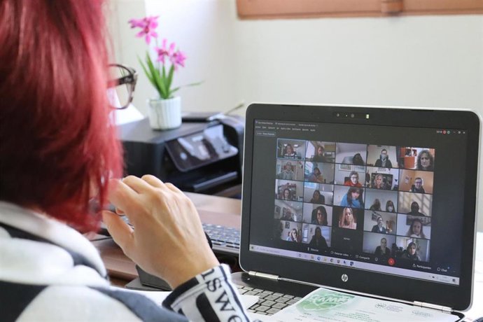 Archivo - Una mujer participa en una videollamada con varias personas.