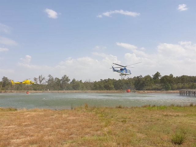Helicópteros cogiendo agua de una charca para apagar el incendio en Sierra de Gata