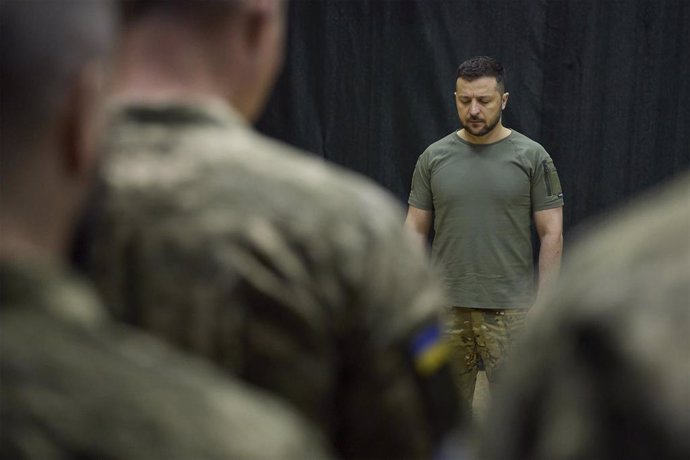 El presidente ucraniano, Volodimir Zelenski, guarda un minuto de silencio junto a un grupo de soldados.