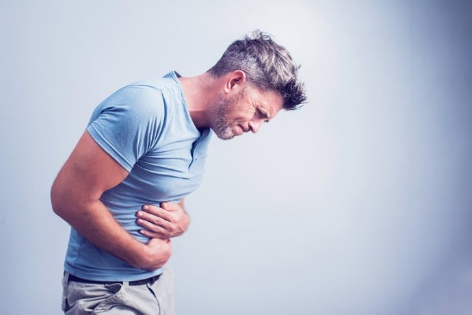 Archivo - People, healthcare and health problem concept - unhappy man suffering from stomach ache over gray background