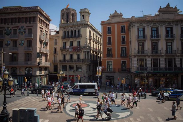 Varias personas caminan por el mosaico de Miró en el suelo de La Rambla, a 4 de agosto de 2022, en Barcelona.