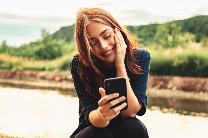 Archivo - Felicidad suerte sonriente mujer joven en videollamada