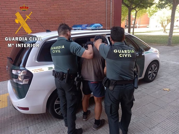 Momento en el que los agentes introducen en el coche patrulla a uno de los detenidos.