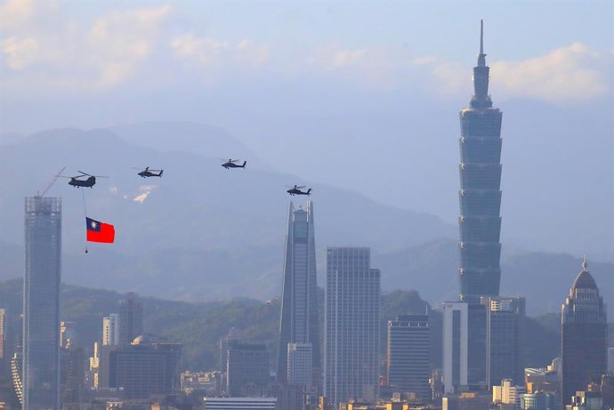 Archivo - 05 October 2021, Taiwan, New Taipei City: A military helicopter carrying a tremendous Taiwan flag conducts a flyby rehearsal with other helicopters ahead of the Double-tenth National Day celebration, near Taipei 101, amid China's growing milit