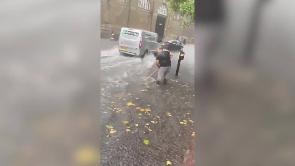 Hay cosas que es mejor tomárselas con humor: así trataba de limpiar este hombre mientras caía un chaparrón