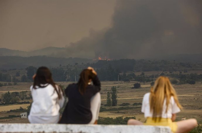 Varias personas observan las llamas y el humo del incendio en Bejís desde el municipio de El Toro, en Castellón.