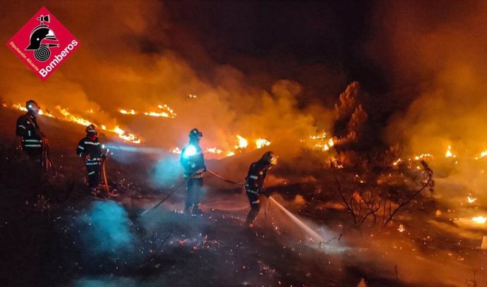 Un grupo de bomberos trata de extinguir un foco del incendio de la Vall d'Ebo