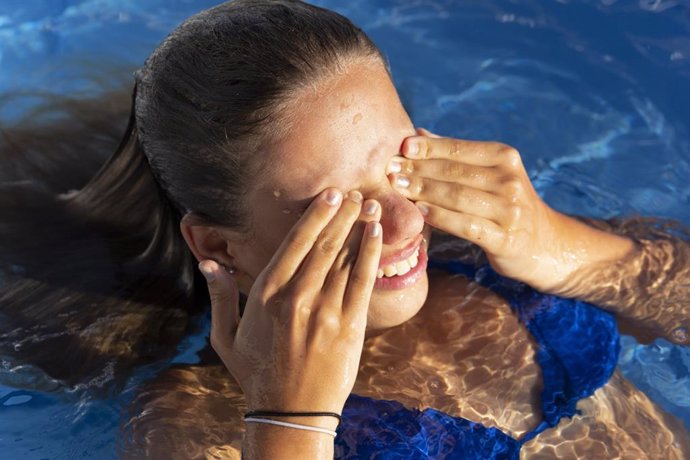 Archivo - Niña frotándose los ojos en la piscina.