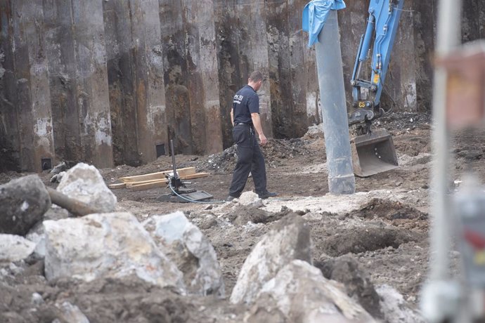 18 August 2022, Berlin: A police officer inspects a construction site near Ostkreuz following the discovery of a 500 kilogram World War II bomb at a construction site. Photo: Paul Zinken/dpa