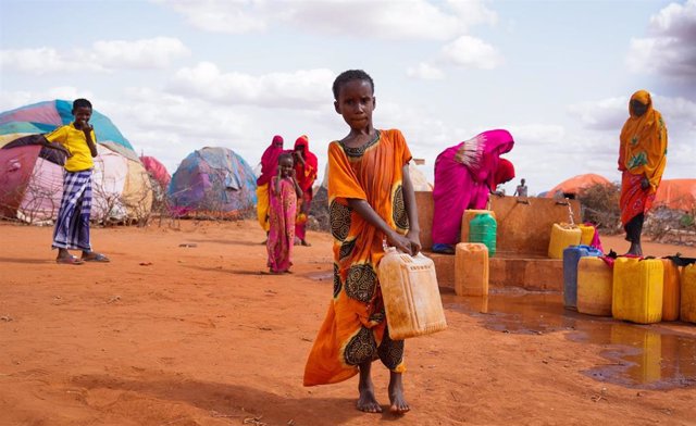 Archivo - Un niño de diez años carga un bidón de agua en un campamento de desplazdos internos en Dollow, Somalia
