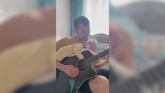 La original forma de este padre de dormir su bebé: tocar la guitarra...¡Con el bebé encima!