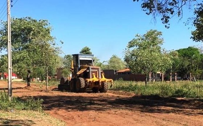 Una maquina trabaja en un camino rural.