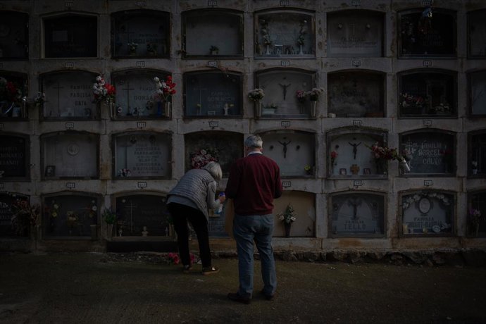 Archivo - Arxiu - Dues persones colloquen flors en un nínxol del Cementiri de Montjuc, a Barcelona, Catalunya (Espanya), a 27 d'octubre de 2020.