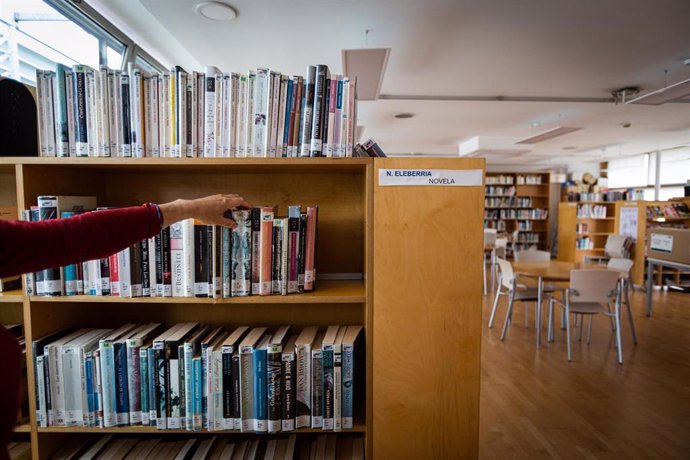 Archivo - Una bibliotecaria coge un libro de una estantería de la Biblioteca municipal del Centro Cívico Aldabe en Vitoria-Gasteiz