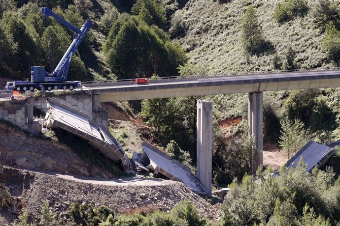 Operarios y grúas trabajan durante el desmontaje del tercer y último vano del viaducto de la A6, a 19 de agosto de 2022, en Vega de Valcarce, León, Castilla y León