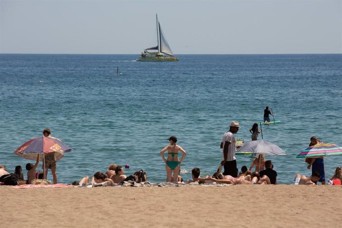 Archivo - Foto de archivo de varias personas en la playa de la Barceloneta