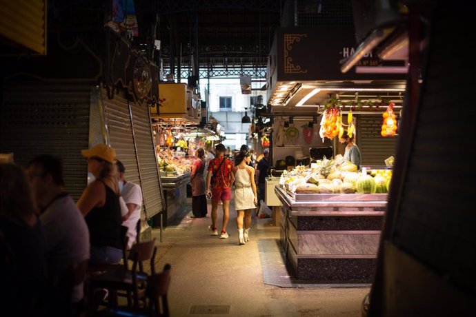 Archivo - Varias personas observan puestos de venta de comida en el mercado de La Boquería, a 5 de agosto de 2021, en Barcelona, Cataluña, (España). 