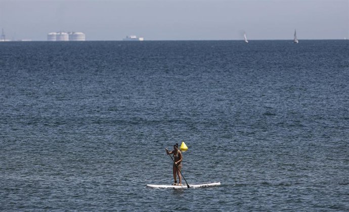 Una mujer hace padelsurf en la Playa de la Malvarrosa