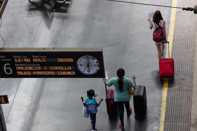 Viajeros caminan con sus enseres en la estación de Ave Madrid - Puerta de Atocha, a 12 de agosto de 2022, en Madrid (España). Hoy es el primer día del puente del 15 de agosto y el inicio de vacaciones para las personas que eligen la segunda quincena de 