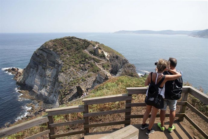 Una pareja en la ruta de Punta Socastro, en O Fuciño do Porco, en agosto de 2022, en O Vicedo, Lugo, Galicia (España).