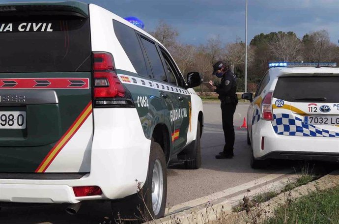 Archivo - Un coche patrulla de la Guardia Civil junto a un vehículo de la Policía Local.