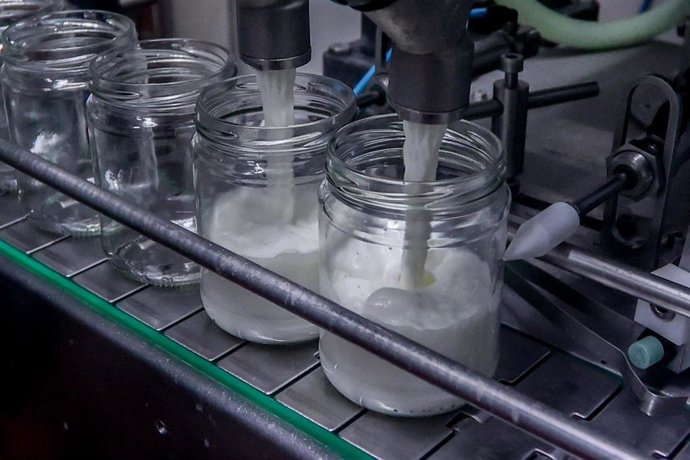 Una máquina llena recipientes en una fábrica.