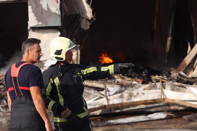 Bomberos durante las labores de extinción del incendio en una nave de plásticos y pegamento de Utrera, en Sevilla.