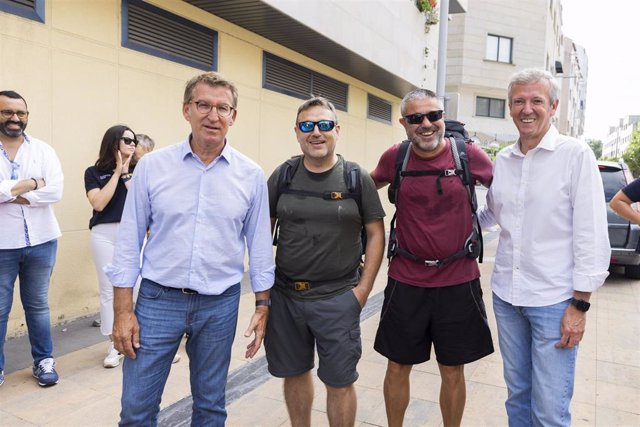 El presidente del Partido Popular, Alberto Núñez Feijóo (1i), y el presidente de la Xunta, Alfonso Rueda (1d), junto a algunos peregrinos en un tramo del Camino de Santiago a su paso por Pontevedra, a 25 de agosto de 2022.